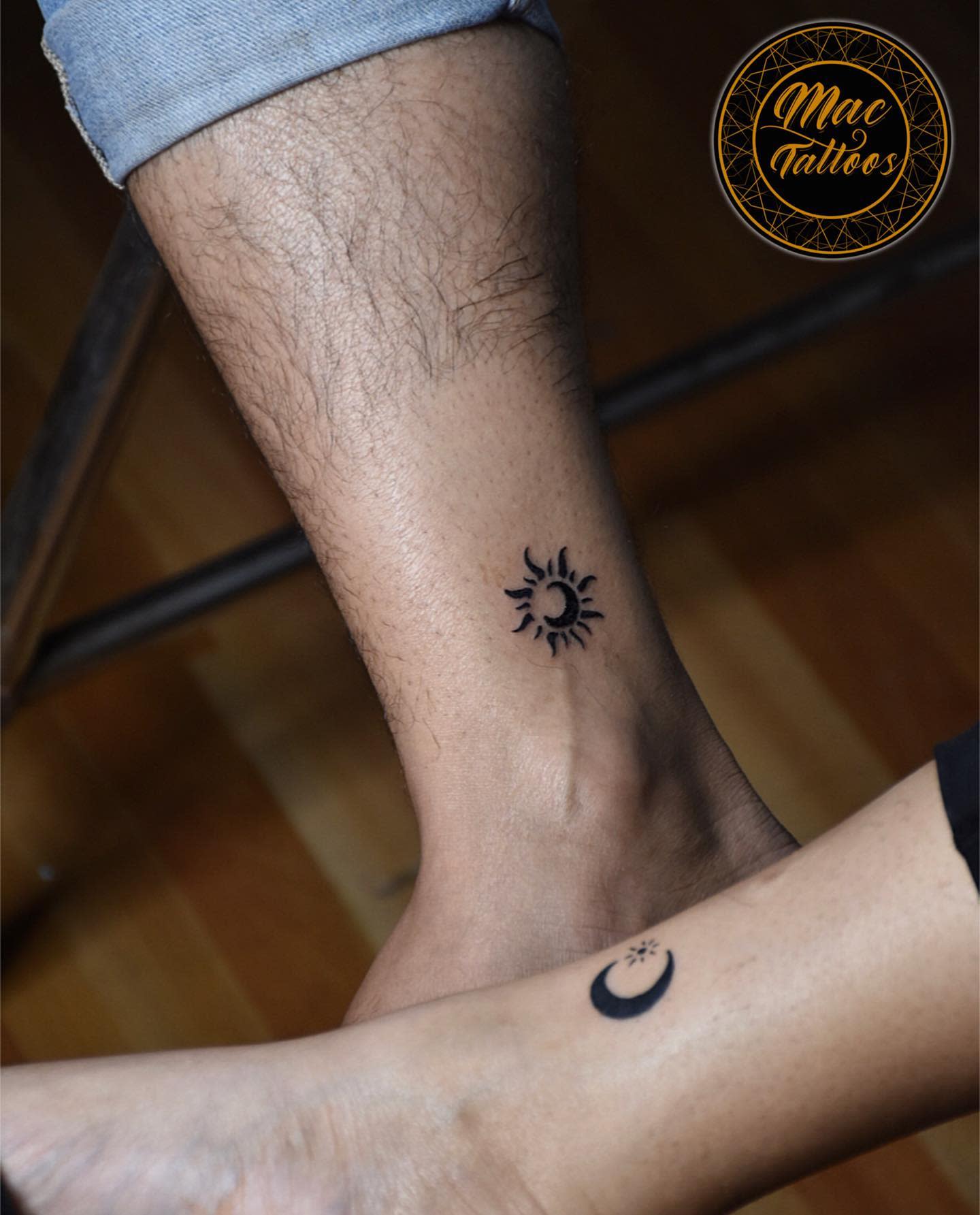 Two ankles with fresh tattoos, one featuring a crescent moon and the other a sun